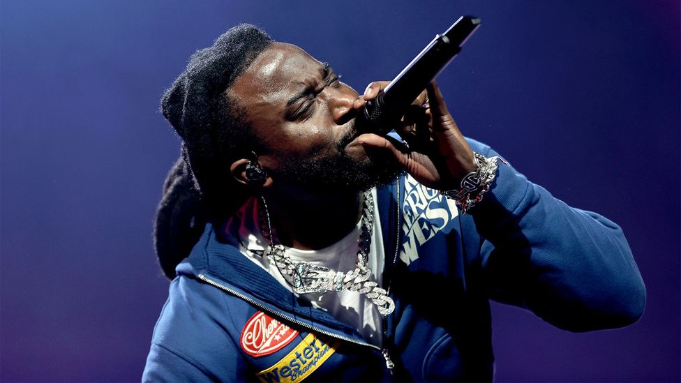 Shaboozey performing, holding a microphone to his mouth (Credit: Getty Images)