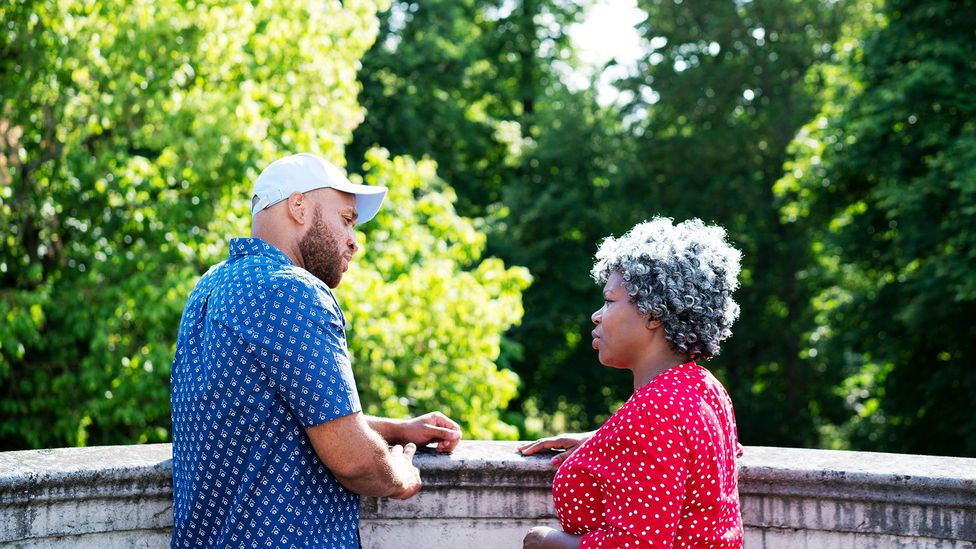 A man and woman facing each other outside with greenery in the background (Credit: Getty Images)