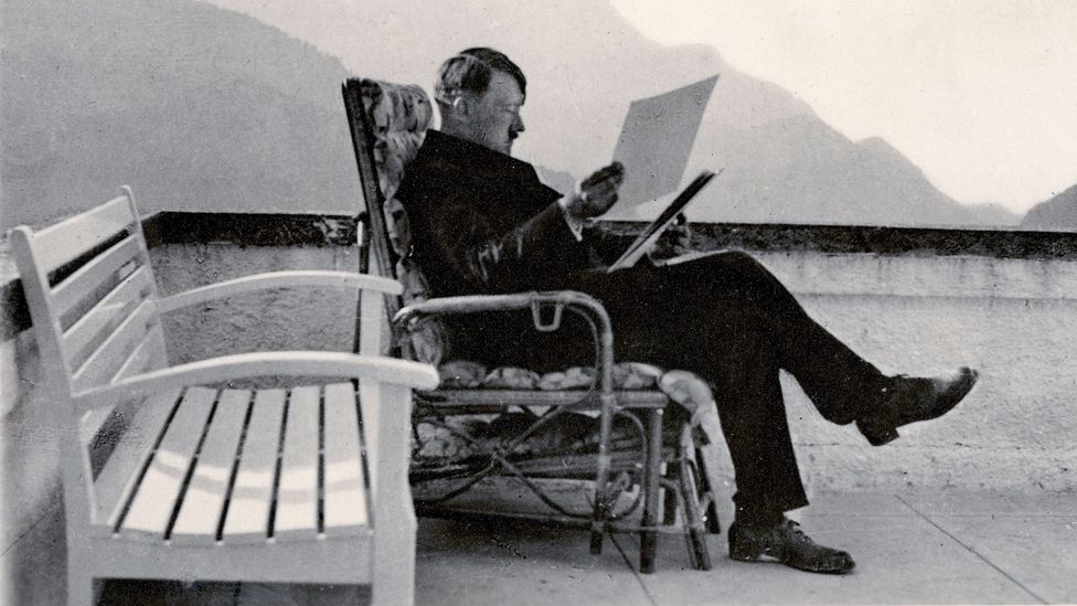 A black-and-white photograph of Hitler sitting on a bench (Credit: Getty Images)