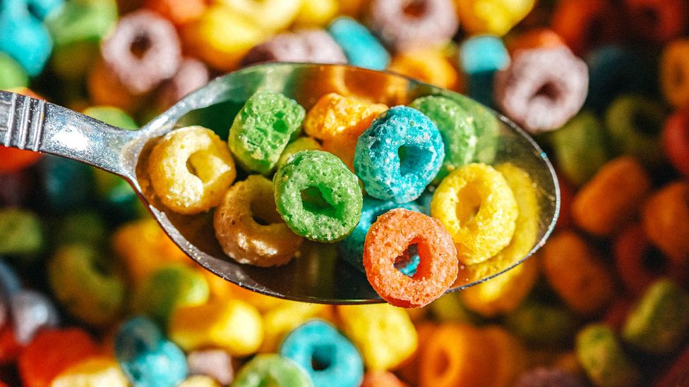 A close up of multi-coloured cereal hoops on a spoon (Credit: Getty Images)