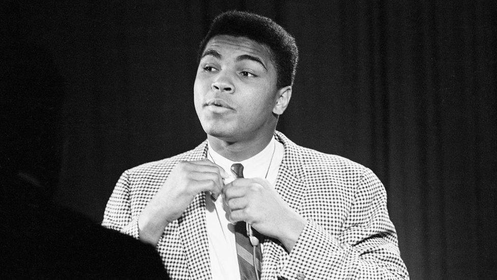 Black-and-white photo of Muhammad Ali fixing his suit (Credit: Getty Images)
