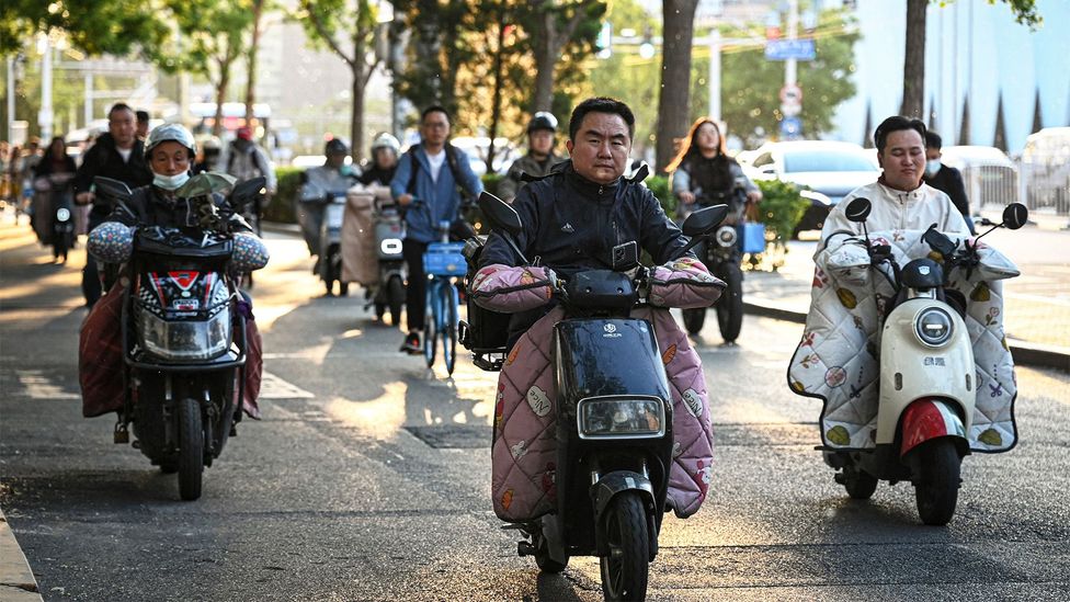 People drive electric scooters to commute to work in Beijing, China (Credit: Getty Images)