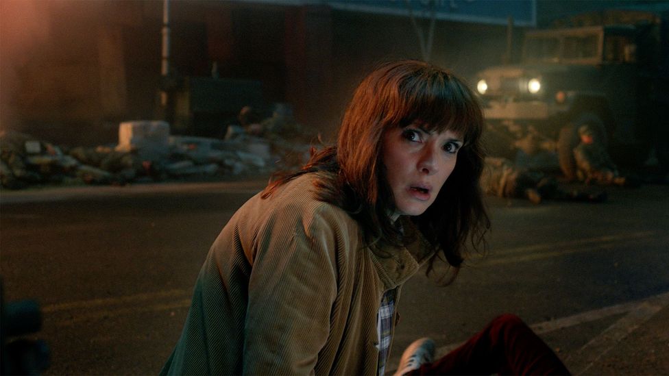Winona Ryder lookinmg scared in a chatotic scene in Stranger Things season 5 (Credit: Netflix)