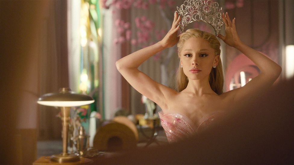 Ariana Grande as Glinda, putting a crown on her head in Wicked: For Good (Credit: Universal Studios)