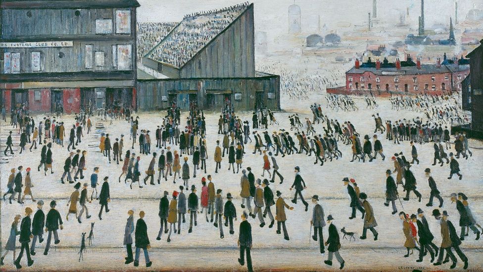 L. S Lowry's painting 'Going to the Match' (1953). It's a painting of a large square with hundreds of people pouring into a Bunden Park stadium, with the skyline of Bolton in the background (Credit: The Estate of L.S. Lowry)