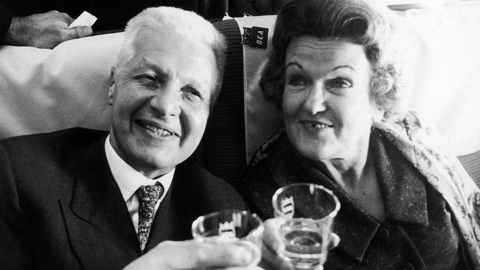 A black and white picture of the Krogers on a plane holding drinks (Credit: Alamy)
