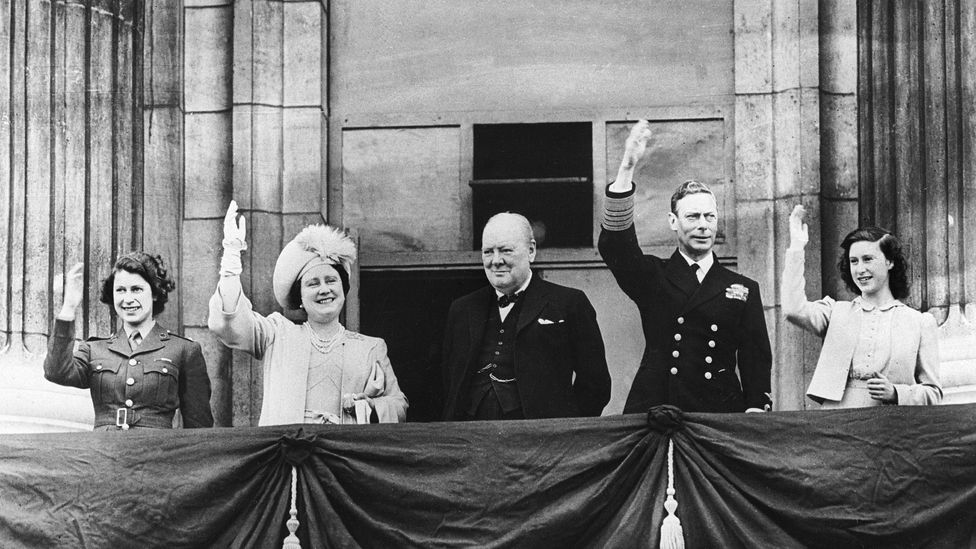 A black and white image of Princess Elizabeth, Queen Elizabeth, Winston Church, King George VI and Princess Margaret waving from the balcony of Buckingham Palace on VE Day 1945 (Credit: Getty Images)
