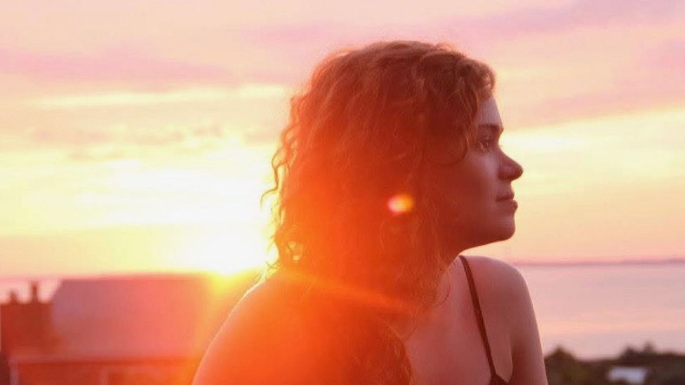 Ally Hirschlag pictured looking off camera with beams of sunlight from the sunset behind her in Cape Cod (Credit: Mark Stetson)