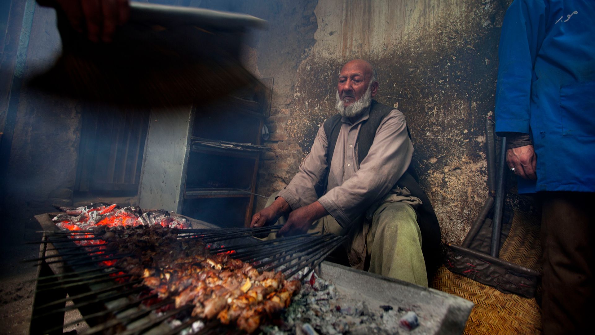 A cook grilling brochettes at a market restaurant in Kabul (Credit: Getty Images)