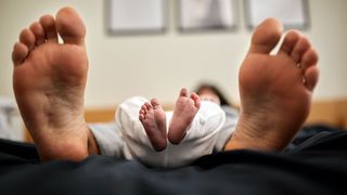 Adult and baby feet side by side (Credit: Getty Images)