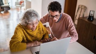 A young man and an older woman look at a laptop (Credit: Getty Images)